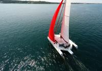 trimaran d'en haut rouge gennaker équipage dans turquoise t-shirts naviguer